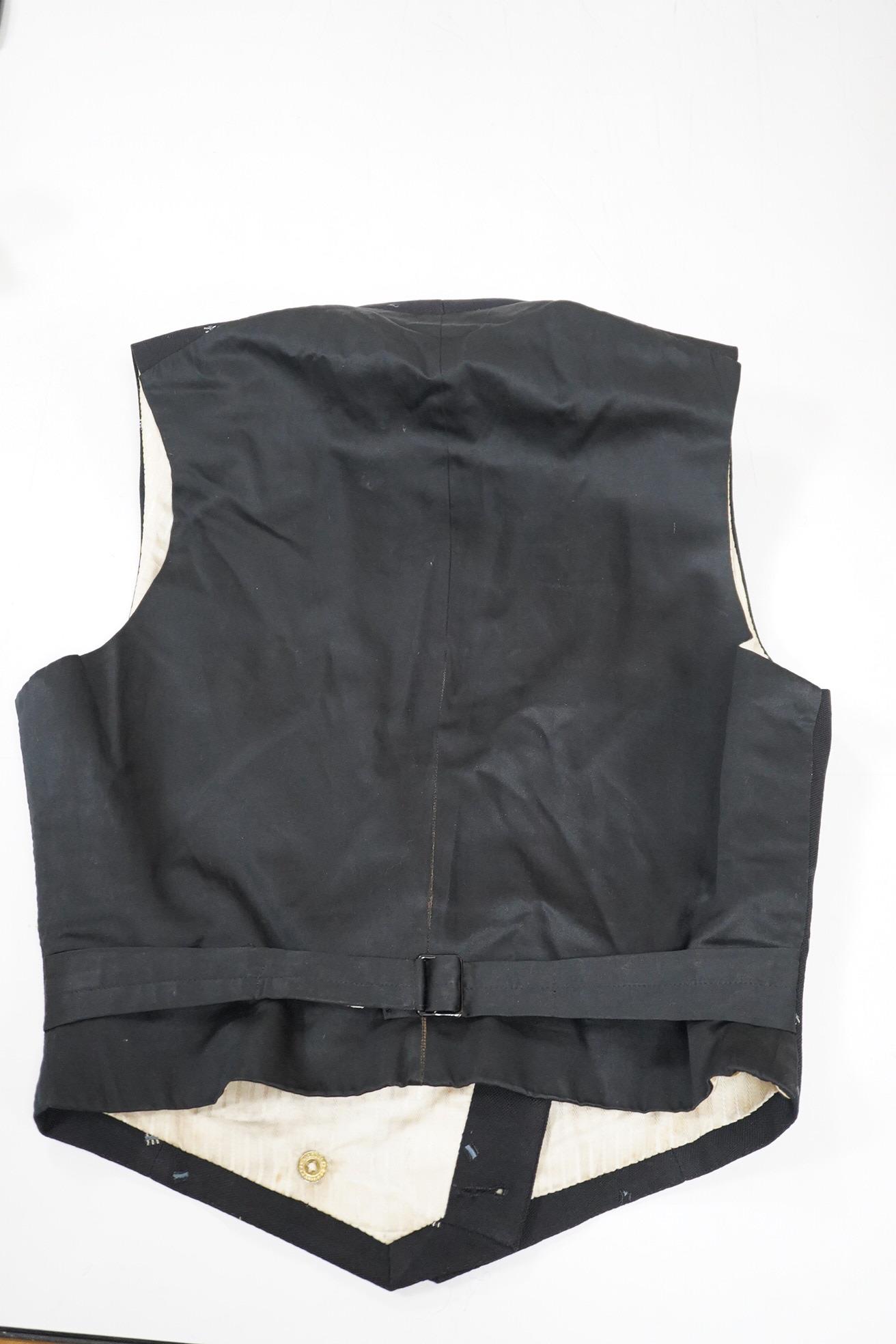 An Edwardian small gentleman’s double breasted waistcoat, made from black woven wool, with a sprig design, under arm chest 36inches. Condition - lining has various rust marks, the waistcoat would benefit dry cleaning